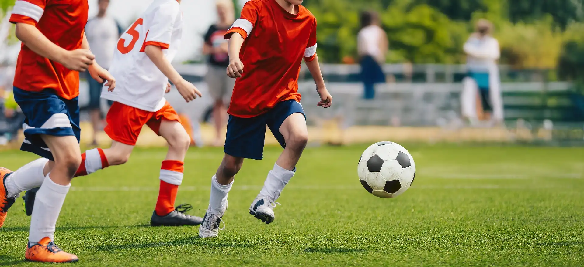Junior football match with boys running and kicking the ball